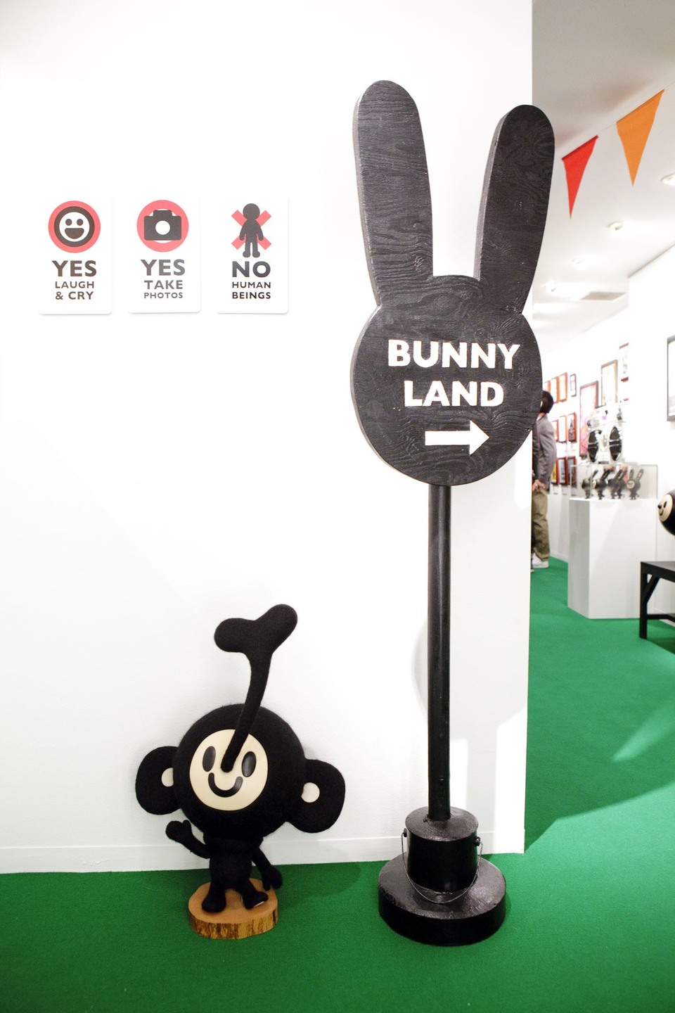 A bunny-shaped BUNNY LAND sign with an arrow, a small rabbit sculpture at its foot, and three wall signs reading YES, YES and NO.